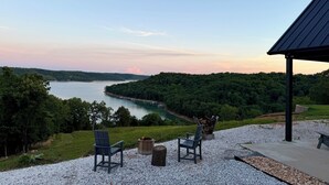 A lakeside view with chairs and a fire pit, surrounded by a gazebo. - Brand-New Beaver Lake Cabin - Lake Views - Fire Pit - Sleeps Up To 9 (Garfield)