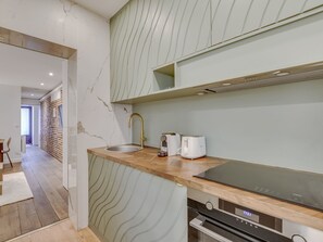 A modern kitchen with a built-in oven, a sink, and a toaster. - Atelier Parisien - 4P - Montparnasse Station (Paris)