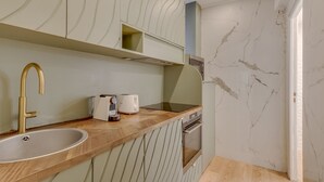 Una cucina moderna con piano di lavoro in legno, lavello in acciaio inossidabile e forno integrato.