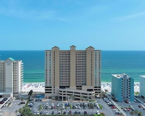 Ein mehrstöckiges Hotel mit Tiefgarage und Blick auf den Strand.