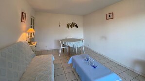 A small, clean room with a bed, a table with glasses, a chair, and a lamp. - T3 Duplex near Capbreton port with parking, 5 pers. (Capbreton)