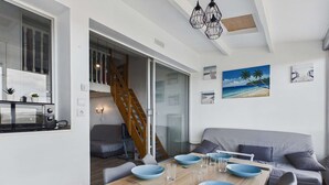 Un espace de vie compact comprenant une table à manger, un canapé et un escalier menant à un niveau supérieur.