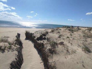 A sandy beach with a wooden pathway leading to the water. - Studio Mezzanine for 6, Pets, Parking, Sea View (Marseillan-Plage)
