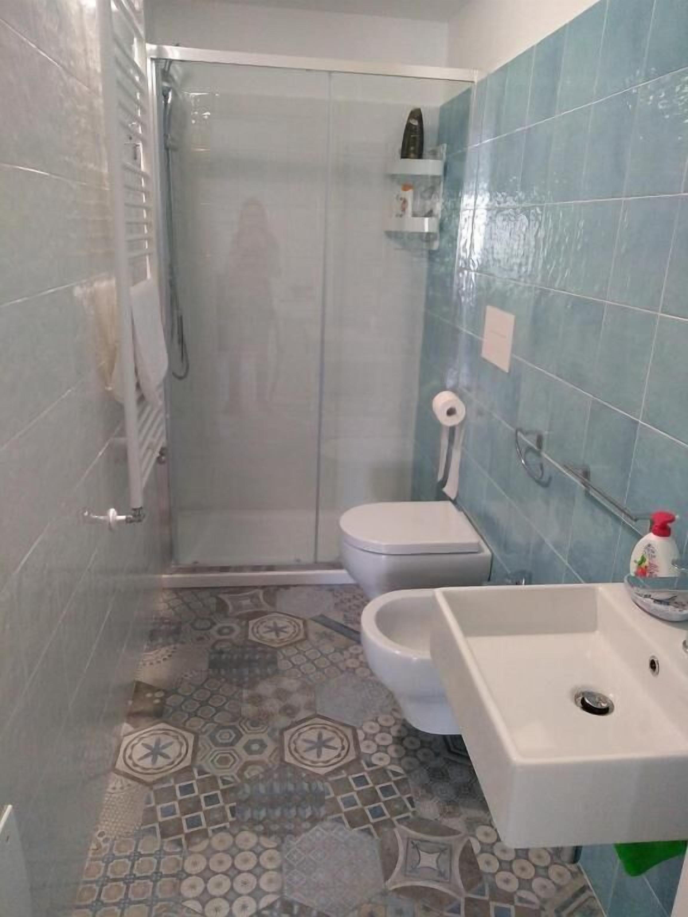 Un baño con ducha, inodoro y lavamanos.