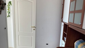 Una camera da letto con un letto, un armadio e una porta che dà su un'altra stanza.
