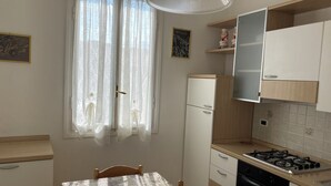 Una cucina con tavolo e sedie, un piano cottura, un forno e un frigorifero.