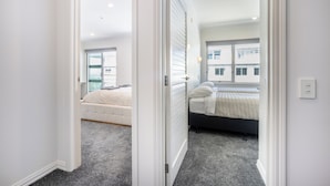 A bedroom with a bed, a window, and a radiator. - Harborfront Penthouse | Free Parking | Chill Vibes (Auckland)