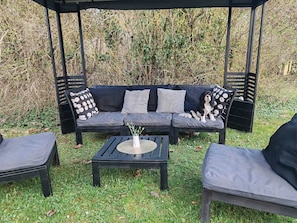 A black outdoor seating area with a sofa, two chairs, and a coffee table.