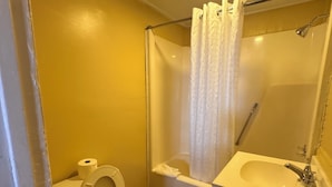 A small bathroom with a toilet, a sink, and a shower. - Welcoming 1-bedroom hotel with AC in Myrtle Beach (Myrtle Beach)