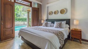 Une chambre avec un grand lit, une table de chevet en bois et une vue sur une piscine.