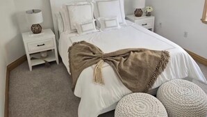 A bedroom with a large bed, two bedside tables, a ceiling fan, and a window. - Tremendous 2-bedroom house with AC in charming Key Largo (Key Largo)