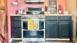 Una cocina compacta con microondas, tostadora, cafetera y horno.