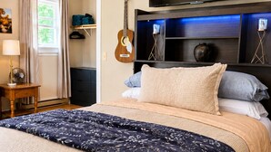 A bedroom with a bed, a TV, a guitar, and a fan. - Parkway Paradise Cozy Retreat Blue Ridge Parkway Family & Pet Friendly  (Laurel Springs)