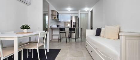 Un espacio habitable compacto con kitchenette, comedor y zona de estar.