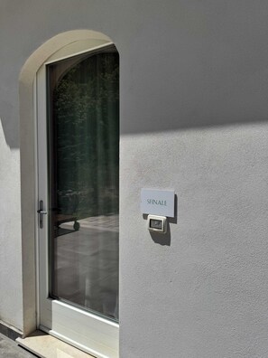 Uma porta com uma placa indicando 'SFINALE' e um teclado de segurança na parede.