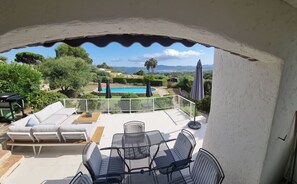 Eine Terrasse mit Gartenmöbeln, einem Pool und Blick auf die Landschaft.