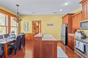 Una cocina con armarios de madera, un refrigerador de acero inoxidable y un horno empotrado.