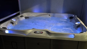 A hot tub with a control panel, a step leading into it, and a dark floor. - Perfect 4-bedroom house with AC in peaceful Port Charlotte (Port Charlotte)