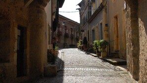 Una calle empedrada bajo un arco, con edificios a ambos lados.