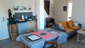 Un espacio habitable compacto con comedor, kitchenette y sofá.
