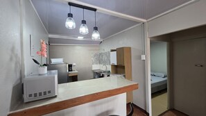 Una cuina compacta amb taulell, cafetera i un rentaplat.