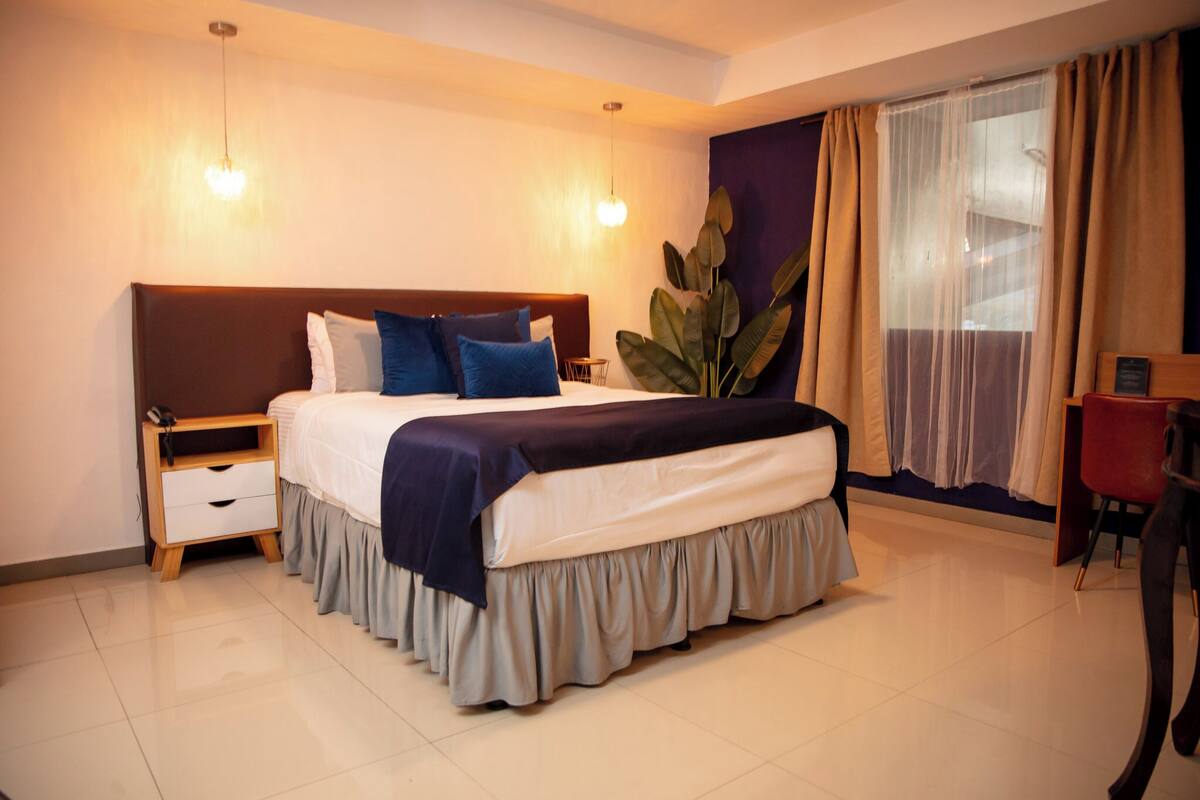 A neatly arranged bedroom with a bed, bedside table, and a chair.