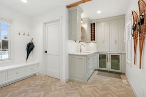 A kitchen with white cabinets, a built-in sink, and a herringbone-patterned floor. - Park Bound Bliss – Steps from Peninsula State Park! (fishcreek)