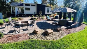 En campingvogn med terrasse, udendørs møbler og et pergola.