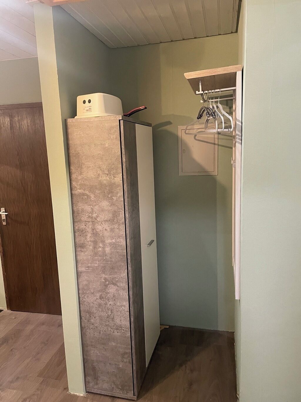 Eine kleine Küche mit einem Edelstahlkühlschrank, einem Holzkorpus und einer Arbeitsplatte.