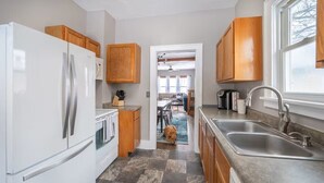 Una cocina con refrigerador, estufa, pileta y gabinetes de madera.