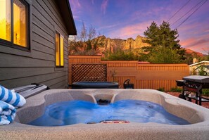 A hot tub in a backyard with a wooden fence, a grill, and a house in the background. - Walk to Uptown + Hot Tub + Cold Plunge + Views (Sedona)