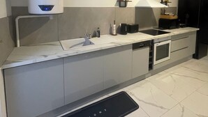 A modern kitchen with a built-in oven, a sink, and a stove. - The station (St Etienne De St Geoirs)