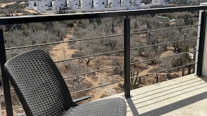 A balcony with a view of a desert landscape, sparse vegetation, and distant buildings. - BRIGHT & COZY 1-KING BEDROOM CASITA WITH QUEEN SLEEPER IN CENTRAL CERRITOS BEACH (Pescadero)