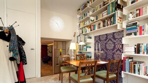 Un coin repas avec une table et des chaises en bois, entouré d’étagères remplies de livres.