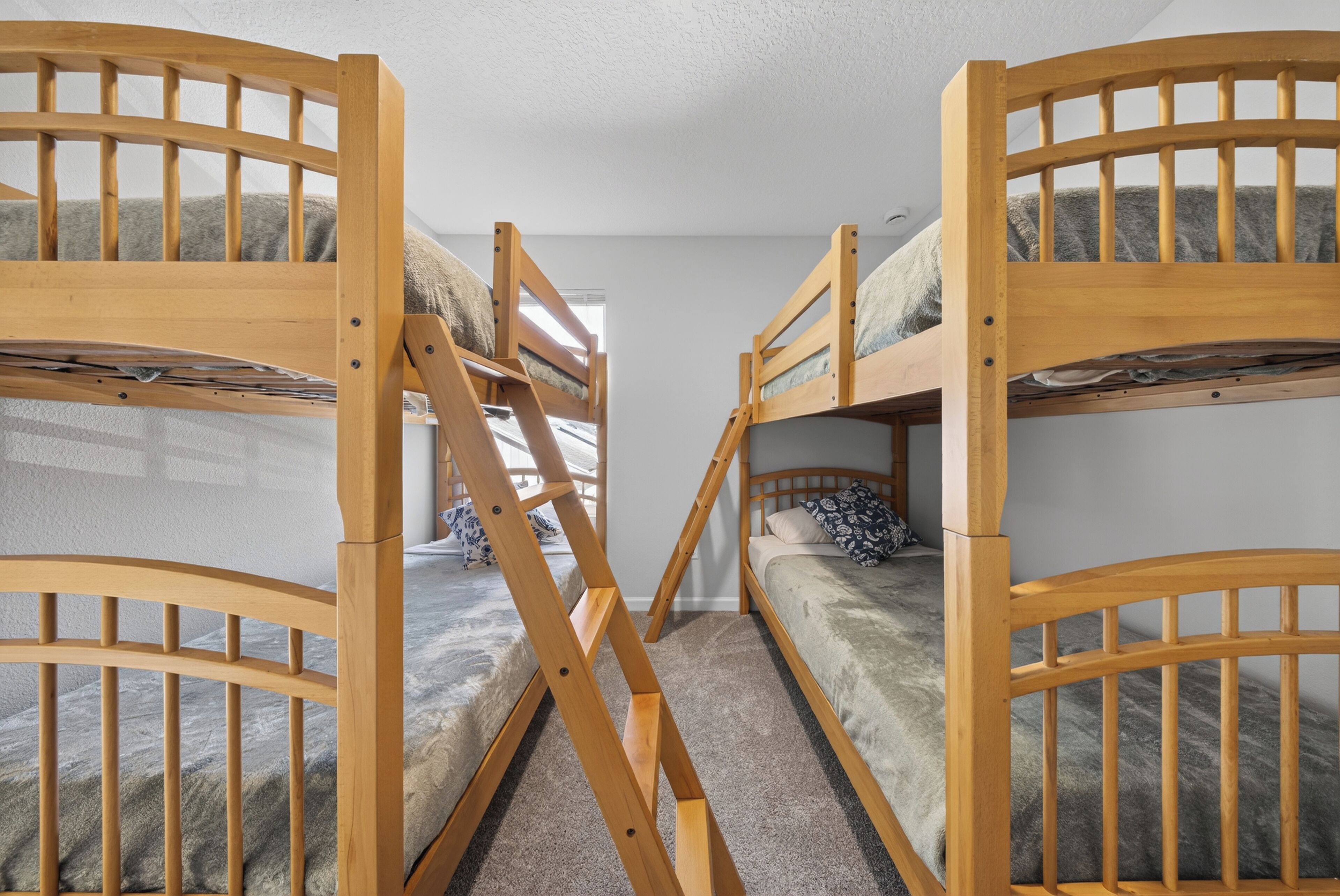 Une chambre avec deux lits superposés, chacun doté d’une structure en bois et d’un matelas.