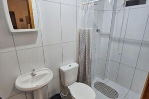 Chuveiro, toalhas de banho, sabonete, papel higiênico