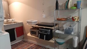 A compact kitchen with a sink, stove, and shelves for storage. - Cozy 1-bedroom studio in tranquil Belgrade with AC (Belgrade)