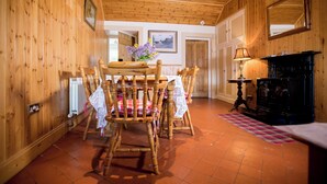 A wooden interior with a dining table and chairs, a fireplace, and a mirror on the wall. - Beautiful 200 year old thatched cottage in the picturesque village of Adare (Adare)