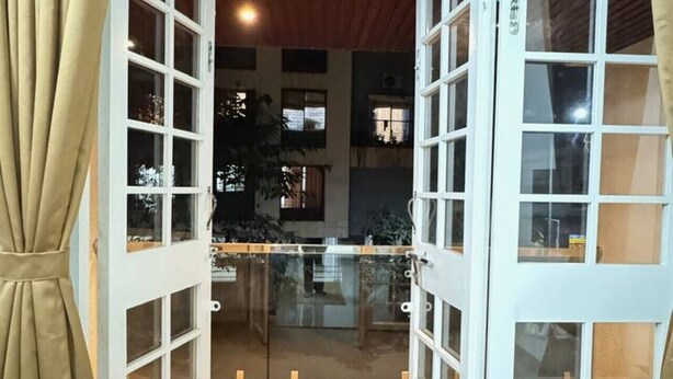 An open door leading to a balcony with a view of the interior of a building. - Osprey House: Modern AC 1BHK Stay by Bleisure (Pimpri-Chinchwad)