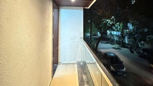 Ein Korridor mit Holzboden und Glastrennwand mit Blick auf eine beleuchtete Straße bei Nacht.