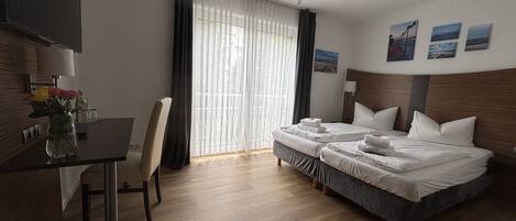 Een hotelkamer met een bed, een bureau, een stoel en een televisie.