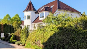 A large, white building with a red-tiled roof and a tower. - Turmhotel Scharbeutz (Scharbeutz)