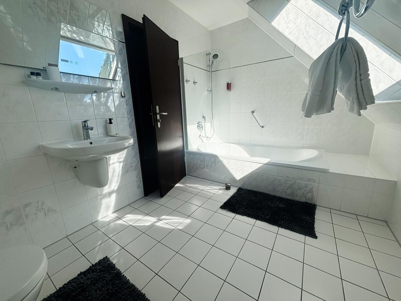 A modern bathroom with a sink, toilet, and shower area.