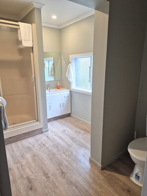 Une salle de bain avec une douche, des toilettes et un lavabo.