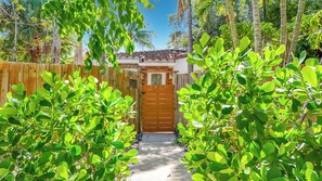 A pathway leading to a wooden gate with the number 1521, surrounded by lush green foliage. - Pool House in Fort Lauderdale (Fort Lauderdale)