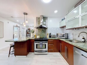 A modern kitchen with a central island, stainless steel appliances, and a backsplash. - Pool House in Fort Lauderdale (Fort Lauderdale)