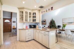 A modern kitchen with a curved island, built-in cabinets, and a dining area with a Christmas tree. - Spacious 4-bedroom house with AC in tranquil Verona 25min from Metlife Stadium (Verona)