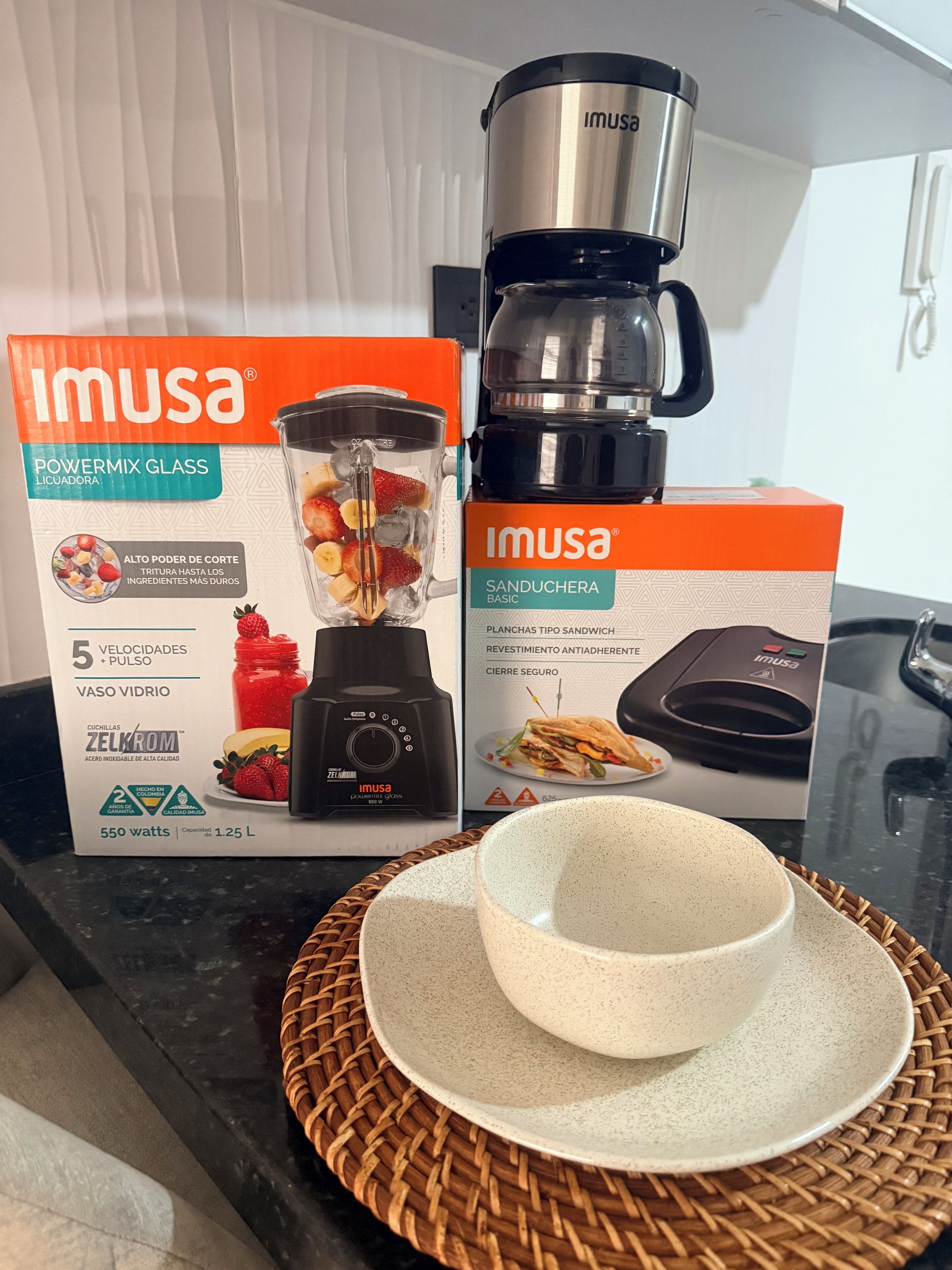 A kitchen counter with a blender and a sandwich maker, both branded 'Imusa'.