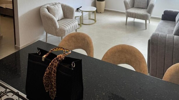 A modern living room with a sofa, chairs, a coffee table, and a dining area with a black countertop. - Suite 1103 (ideal for family travel) (San Gil)