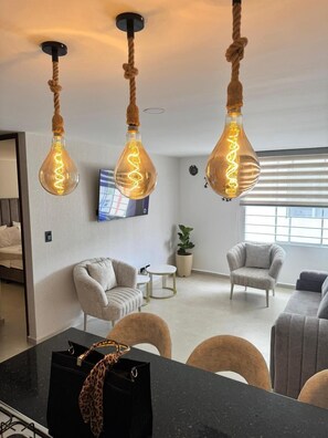 A modern living room with a sofa, chairs, a coffee table, and a dining area with a black countertop. - Suite 1103 (ideal for family travel) (San Gil)